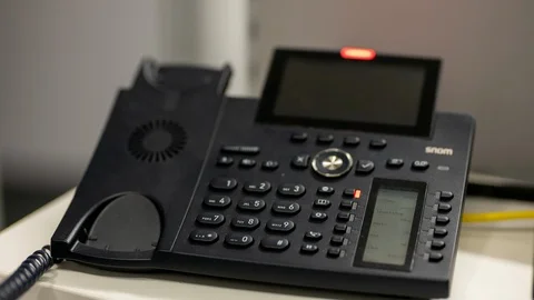 Man hand picking up a ringing office telephone/landline Stock Footage 122054101