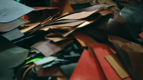 Man hand picks up leather sheets seeking right material Stock Footage 296749698