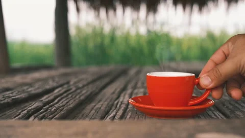 Man hand placing hot ceramic red coffee cup with steam in saucer Stock Footage 163685458
