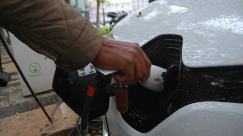 Man Hand Plugging Cable into Electric Car Stock Footage 339515057