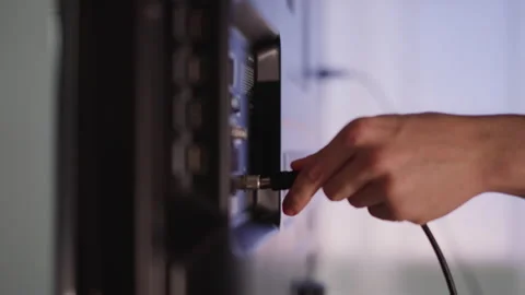 Man hand plugs cable to smart TV on blurred background Stock-Footage 174765954