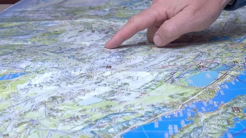 Man hand points the route on a road map Stock Footage 166829042