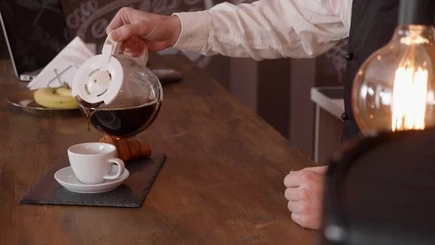 Man hand pour coffee from a pitcher on a bar counter Stock Footage 103597624