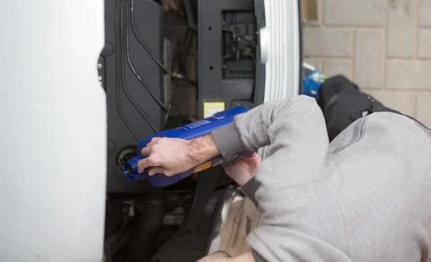 Man hand pouring engine oil to car, repairing broken car engine 库存照片