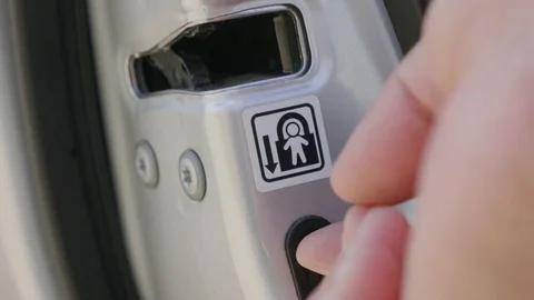 Man hand pressing on child lock button at car's door Stock Footage 84709675
