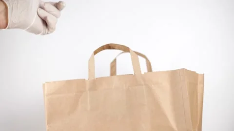 Man hand in protective gloves give order with hot food in aluminum container Vidéo 149812695