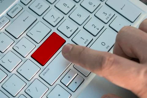 Man hand push button. Red button on grey silver laptop keyboard. Ccopy space  Stock Photos