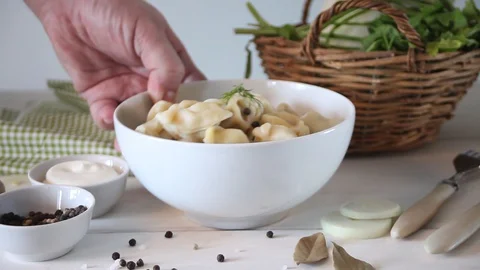 Man hand put abowl with russian pelmeni meat dumplings italian ravioli Stock Footage 128414925