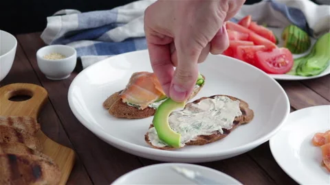 Man hand put avocado slices on healthy sandwich close up Stock Footage 124682374