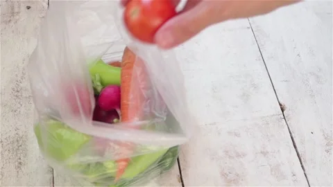 Man hand put fresh vegetables from plastic bag close up Stock Footage 119432175