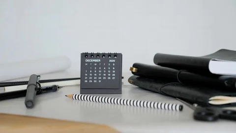Man hand put small black calendar on office desk. December month 2020 Year. Stock Footage 129500839