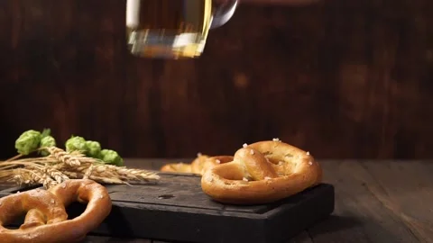 Man hand puts back a mug of light beer on a dark wooden table. Stock Footage 115564649