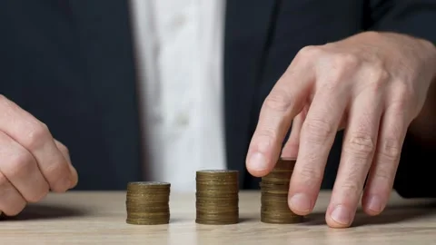Man hand putting coin stack on money staircase Stock Footage 252587925