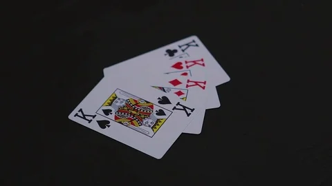 Man hand putting four king poker cards on the black table Stock Footage