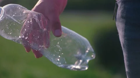 Man hand releases plastic bottle in park on grass. Littering of nature with plas Stock Footage 222836268