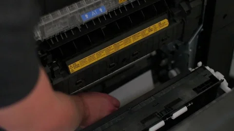 Man hand removing paper stuck in printer at office Stock Footage 74004539