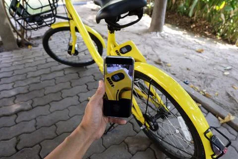 Man hand scanning qr code to unlock bike. Stock Photos