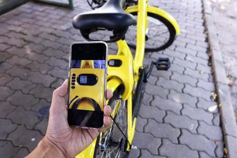 Man hand scanning qr code to unlock bike. Stock Photos