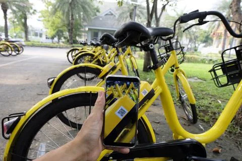 Man hand scanning qr code to unlock bike. Stock Photos