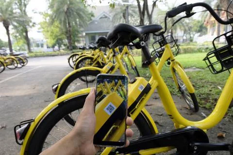 Man hand scanning qr code to unlock bike. Stock Photos