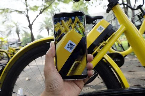 Man hand scanning qr code to unlock bike. Stock Photos