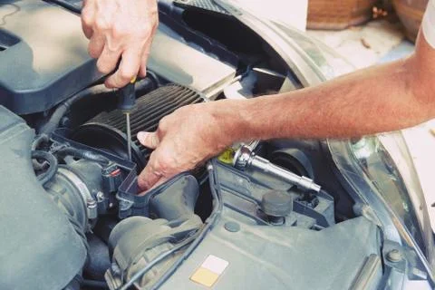 Man hand with screwdriver checking car engine Stock Photos