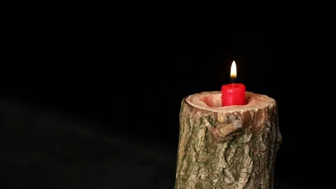 Man hand set on fire on candle in wooden candlestick black background, red candl Stock Footage 170371621
