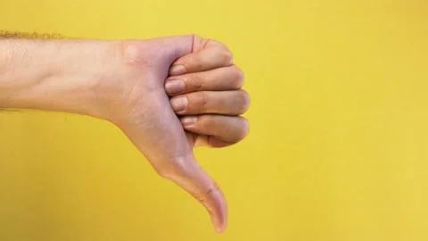Man hand show thumbs down gesture isolated yellow background Stock Footage 130998786