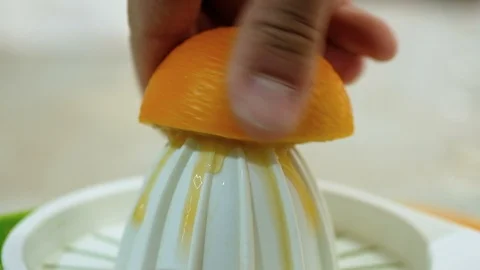 Man hand squeeze fresh orange fruit on juicer,healthy breakfast prepare,vitamin Video stock 127376891