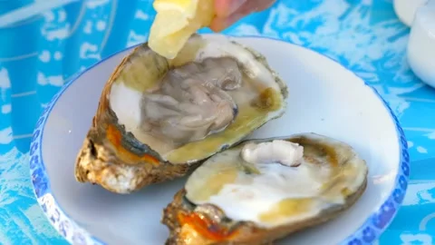 Man Hand Squeeze Lemon on Freshness Oyster in Outdoor Seafood Restaurant 库存影片 155057969