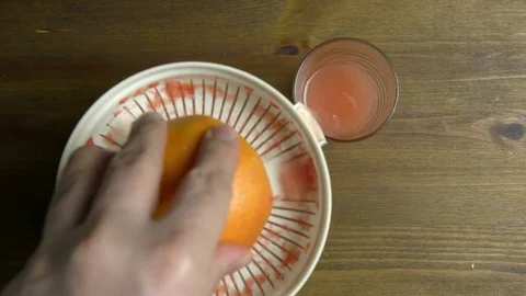 Man Hand with Squeezer Squeezing Grapefruit Juice Top View Video stock 76521683