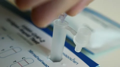 Man hand squeezes liquid in a plastic tube to test for coronavirus at home Видео 186019648