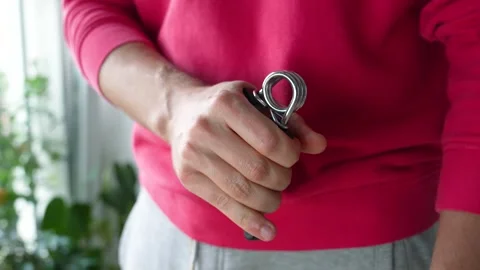 Man hand squeezing spring hand exerciser. Grip strength training, muscle Stock Footage 315344062