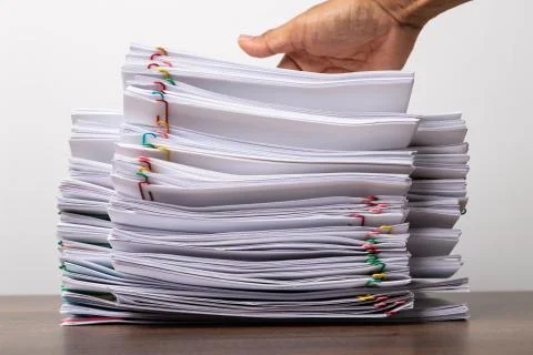 Man hand on stack of over load document. Stock Photos