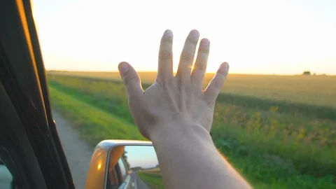 Man hand at sunset. A man's hand from the window of a car in the sun's rays on Stock Footage 98831491