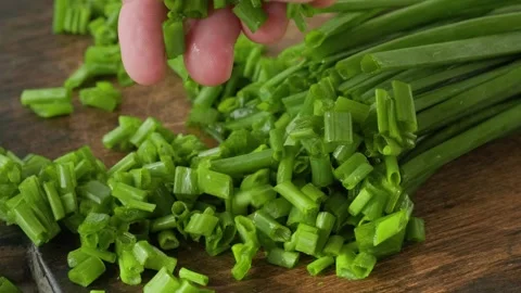 Man hand take chopped spring or green onion on wooden cutting board. Cooking Stock-Footage 251014592