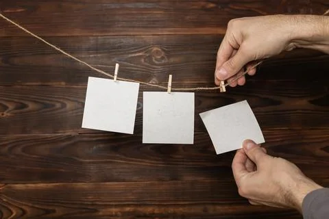 Man hand take paper note cards hanging with wooden clip or clothespin on ro.. Stock Photos