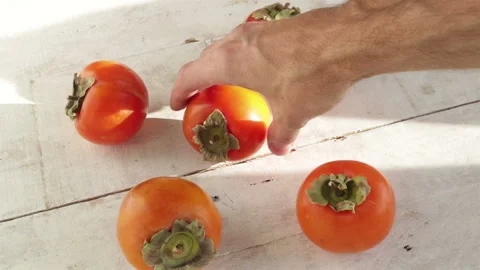 Man hand take persimmon fruit from table close up Stock Footage 119801944