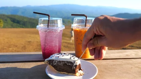 Man hand take a piece of chocolate cake by spoon in outdoor cafe Stock-Footage 220733586