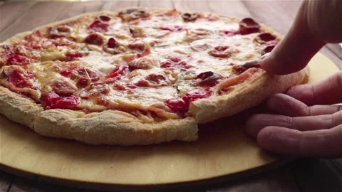 Man hand take a pizza slice with stretching cheese sausage tomatoes close up Stock Footage 115501284
