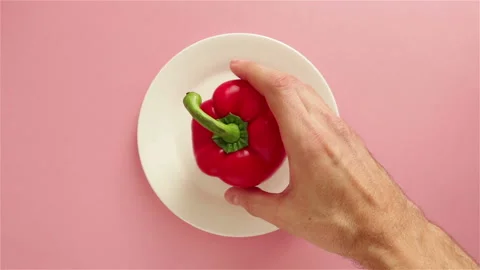 Man hand take red bell pepper from white plate top view Stock Footage 123458198