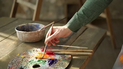 Man hand takes a brush from the table where the drawing tools are lying. Stock-Footage 154260824