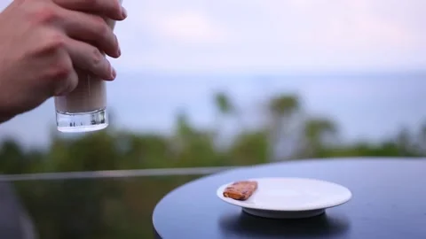 Man hand taking coffee cup on sea view. Male human arm takes mug with hot Stock Footage 232656594