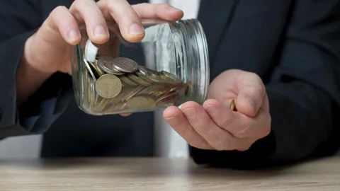 Man hand taking coins from glass jar, close-up Stock Footage 252588694