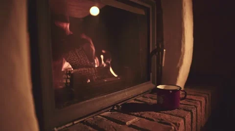 Man Hand taking Cup of Hot Drink, Relaxing Near the Burning Fireplace, 4K. Vidéo 66730745