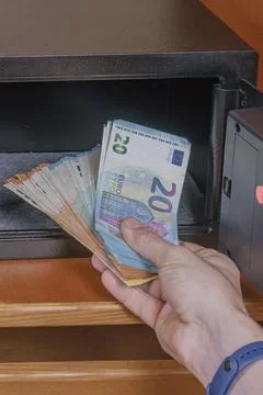 Man hand taking stack of euro banknotes out of open small electronic safe b.. Stock Photos
