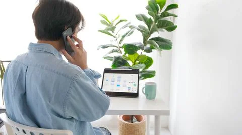 Man hand talking phone while working with digital tablet for mobile app devel Stock Photos