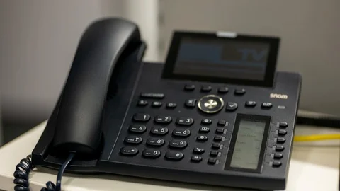 Man hand terminating a call on an office telephone/landline Stock Footage 122053569