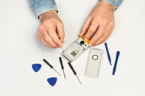 Man hand with tools repearing a smart phone in a top view Foto stock