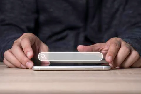 Man hand touching on smart mobile phone to input wording for searching Stock Photos
